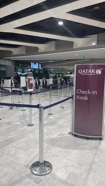 Zone de check-in Qatar Airways à l'aéroport, bornes libre-service et barrières de file d'attente