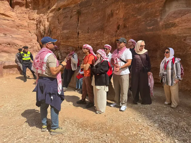 Guide expliquant l'histoire du site à un groupe de visiteurs dans les gorges de Pétra