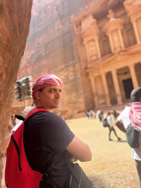 Visiteur avec keffiyeh rouge posant devant le Trésor de Pétra, Jordanie