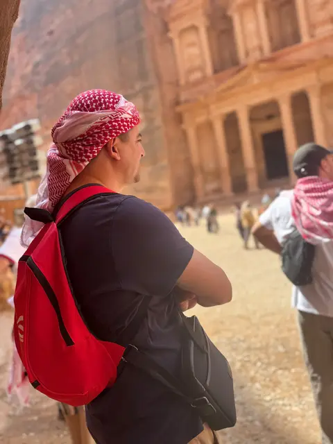 Voyageur en ghutra rouge admirant la façade antique de Pétra, Jordanie