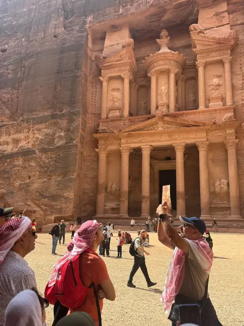 Groupe de voyageurs admirant le Trésor (Al-Khazneh) taillé dans la roche rose de Pétra, Jordanie.