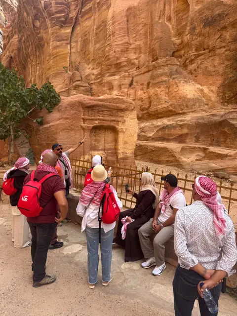 Visite guidée à Pétra : groupe écoutant les explications devant les tombeaux taillés dans la roche