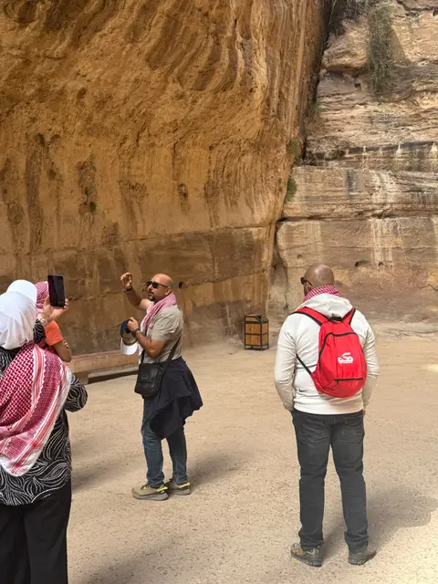 Groupe de voyageurs photographiant les falaises sculptées de Pétra