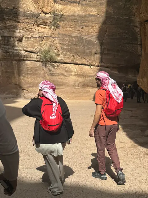 Deux pèlerins progressant dans le Siq de Pétra vers les monuments