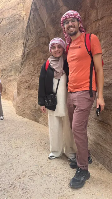 Deux voyageurs posant devant les falaises de grès de Pétra