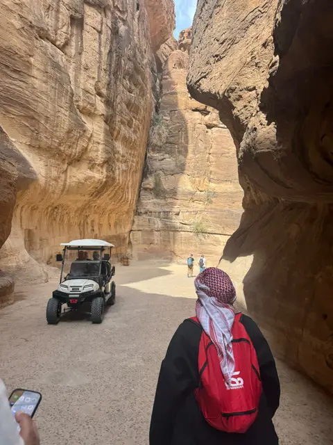 Visiteurs dans les gorges rocheuses de Pétra avec un véhicule électrique