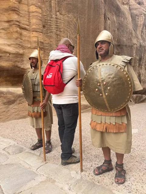 Visiteur en photo souvenir avec deux figurants en costume de guerriers nabatéens à Pétra
