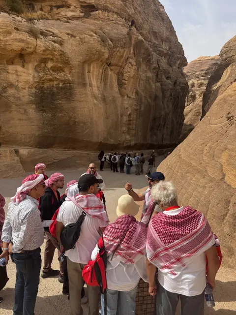 Groupe de voyageurs devant les imposantes falaises rocheuses de Pétra en Jordanie