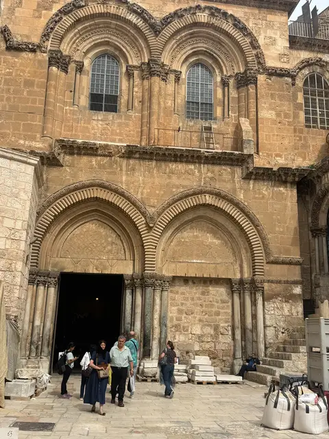Façade en pierre ornementée d'un monument historique de Jérusalem avec visiteurs