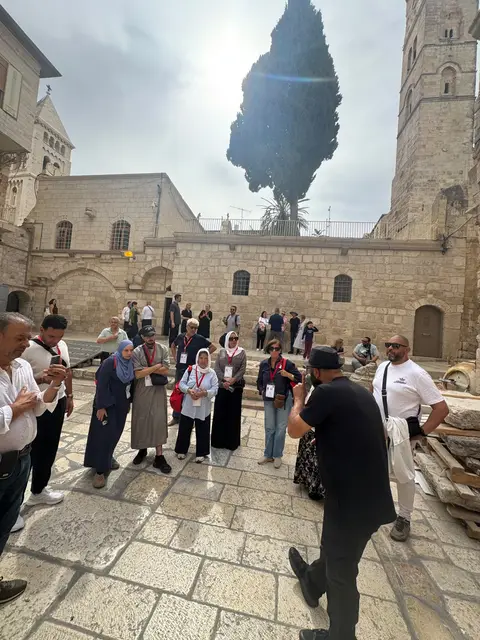 Groupe de voyageurs en visite guidée dans une cour historique de Jérusalem