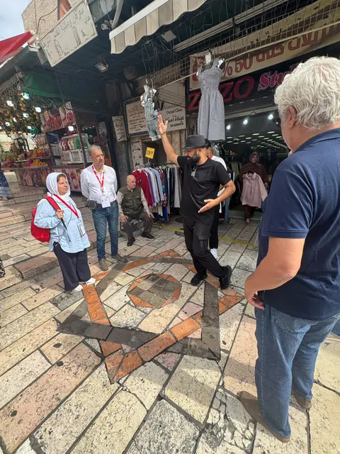 Guide expliquant un point historique dans une rue du souk de la vieille ville