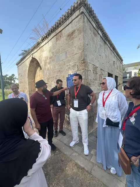 Groupe en visite guidée devant une ancienne porte historique en pierre à Jaffa