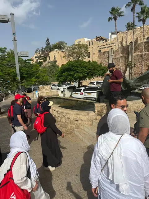 Groupe de voyageurs en visite dans la vieille ville de Jaffa près d'une fontaine historique