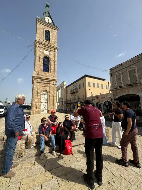 Groupe de voyageurs devant le clocher à horloge ottoman de la place de l'Horloge à Jaffa